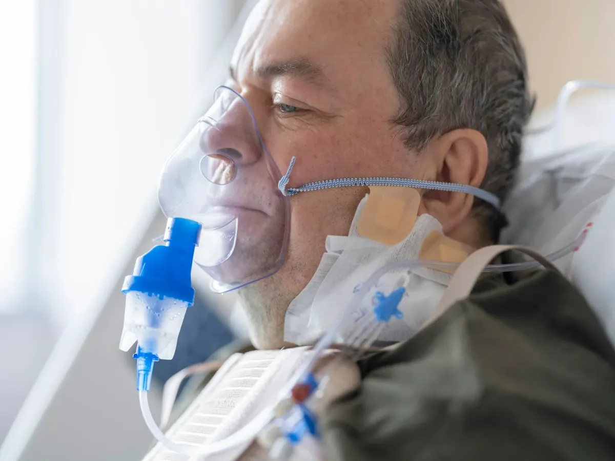 Paciente em leito hospitalar recebendo oxigênio suplementar por máscara