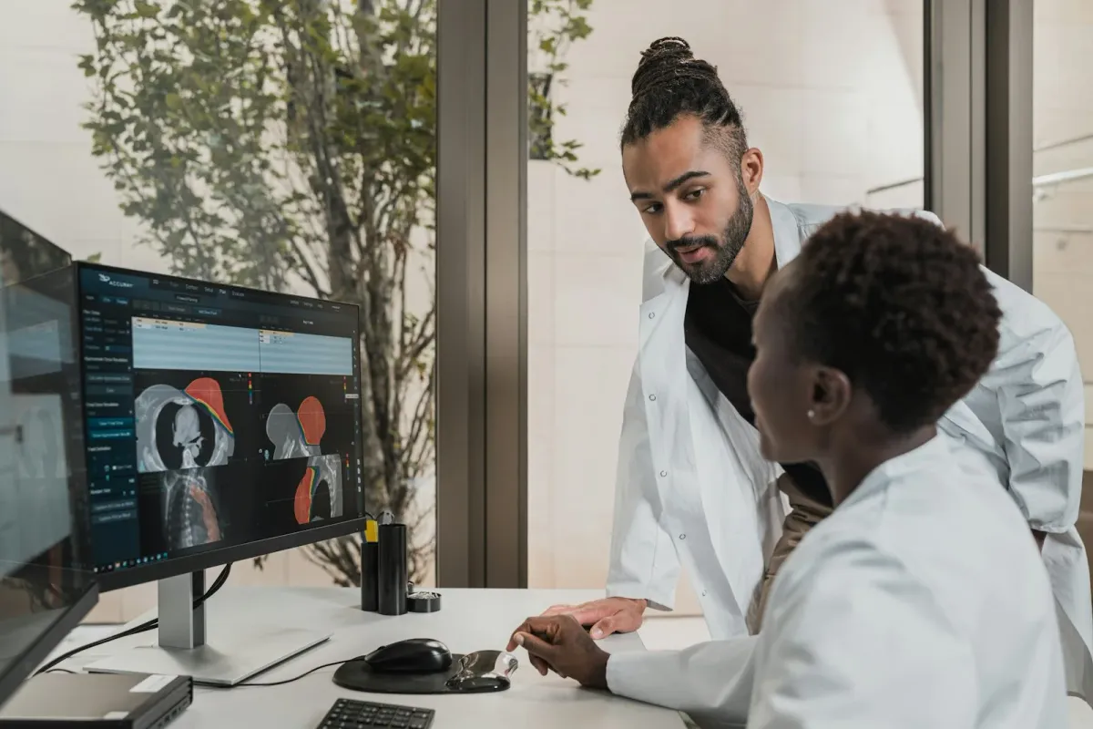 Dois médicos analisam imagens de tomografia de crânio em um monitor