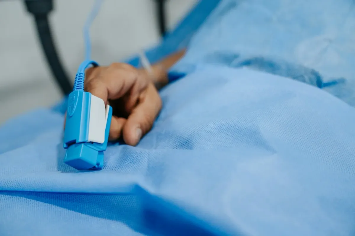 Oxímetro de pulso no dedo de um paciente monitorado em ambiente hospitalar