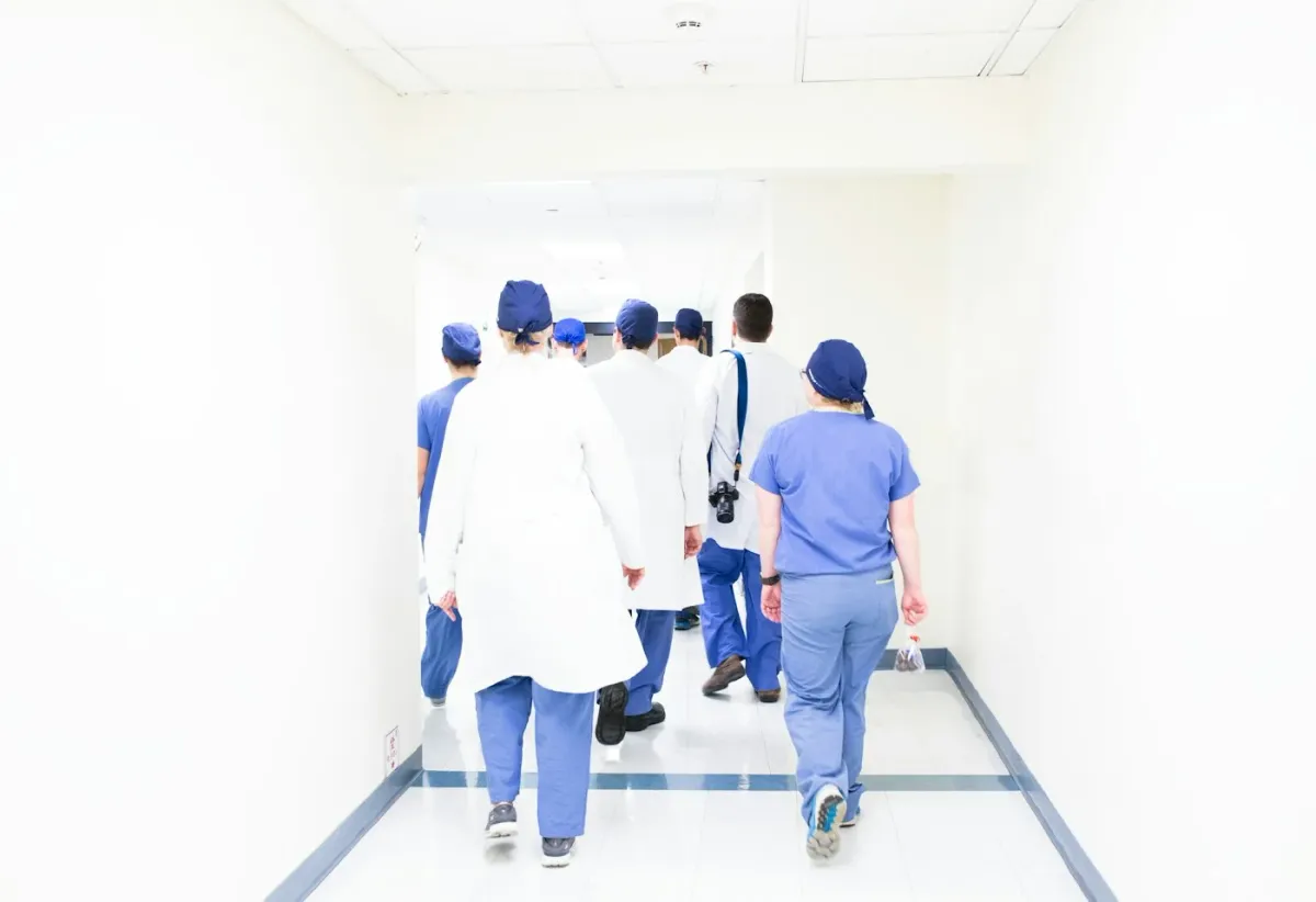 Equipe de saúde caminha pelo corredor do hospital na troca de plantão