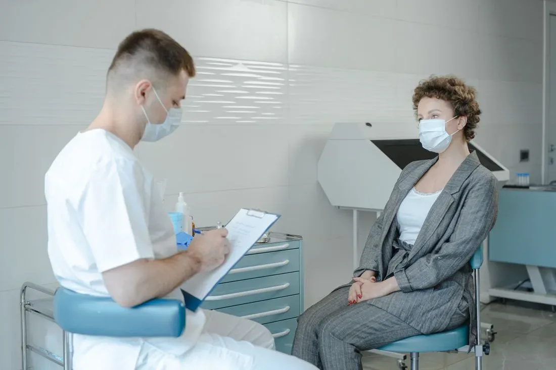 Médico atende uma paciente em consulta, com prancheta em mãos