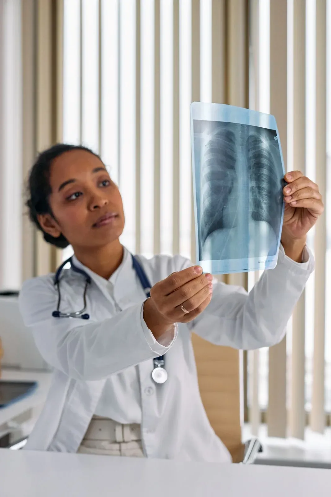 Médica examina uma radiografia de tórax contra a luz