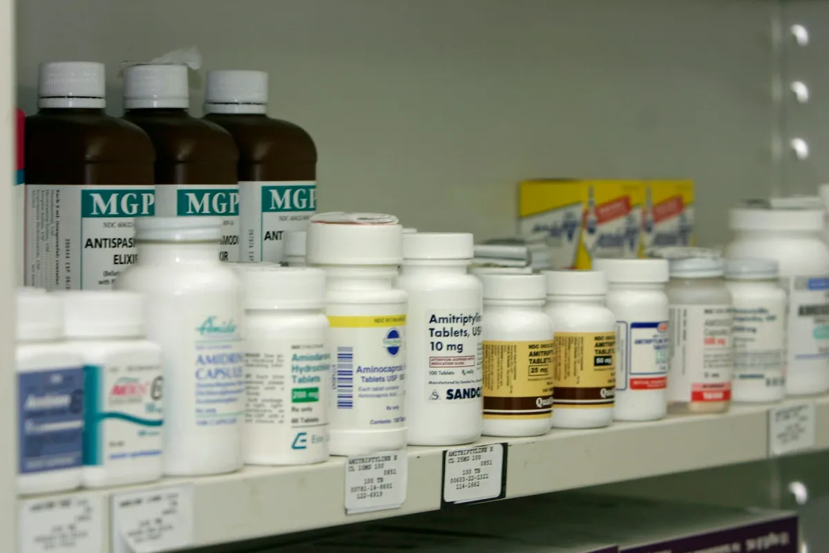 Prateleira de farmácia com frascos de diferentes medicamentos