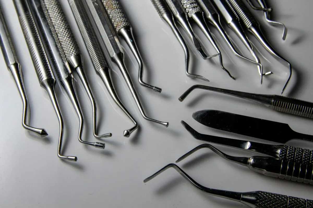 Instrumentais cirúrgicos de aço inoxidável dispostos sobre uma superfície clara
