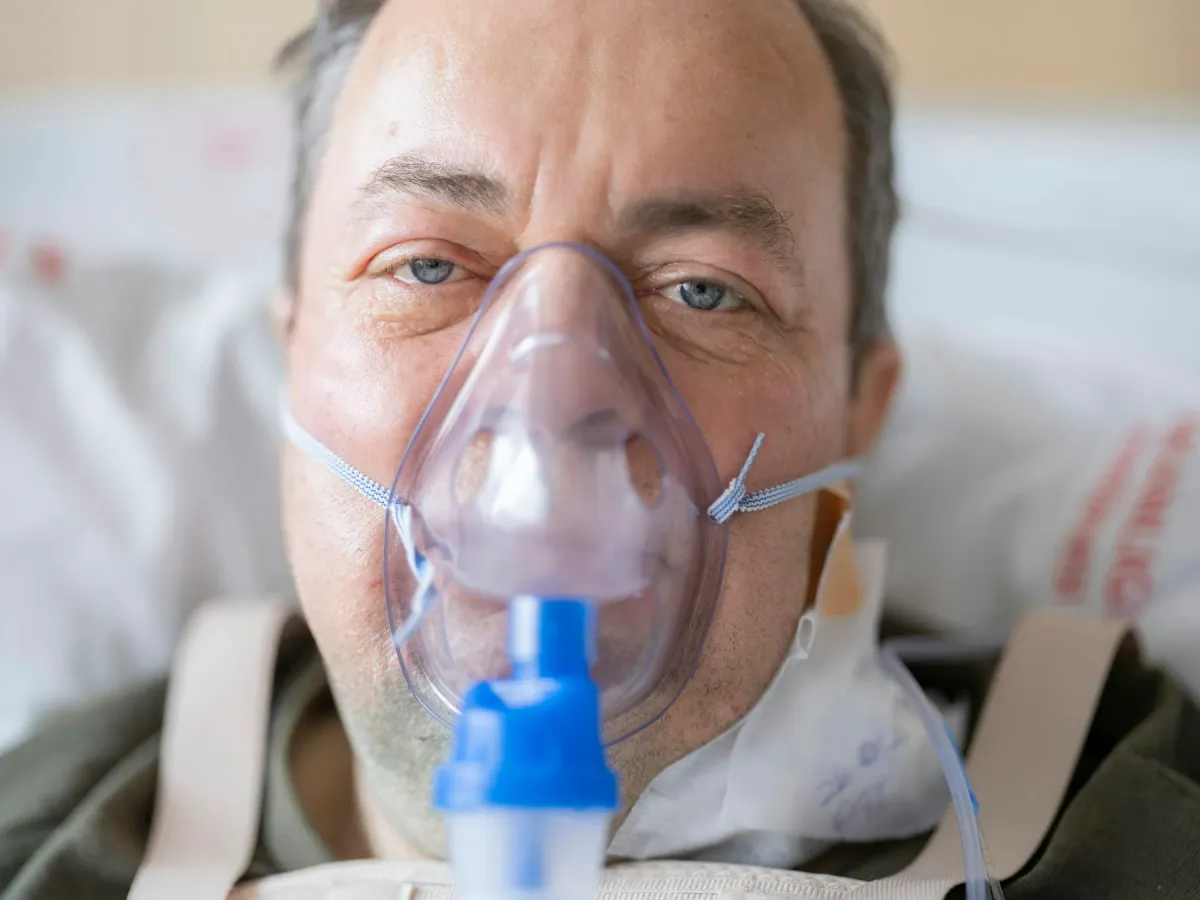 Paciente com máscara de nebulização recebendo tratamento respiratório