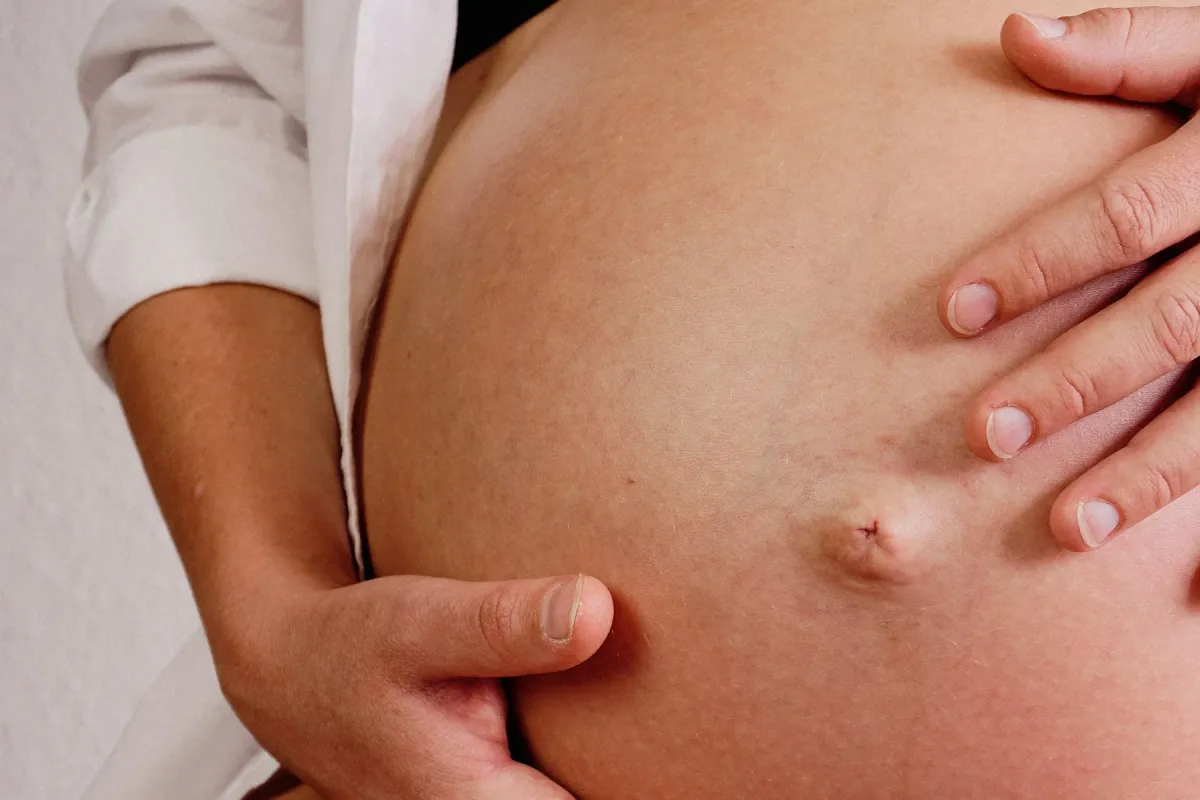 Mãos sobre a barriga de uma gestante, em close