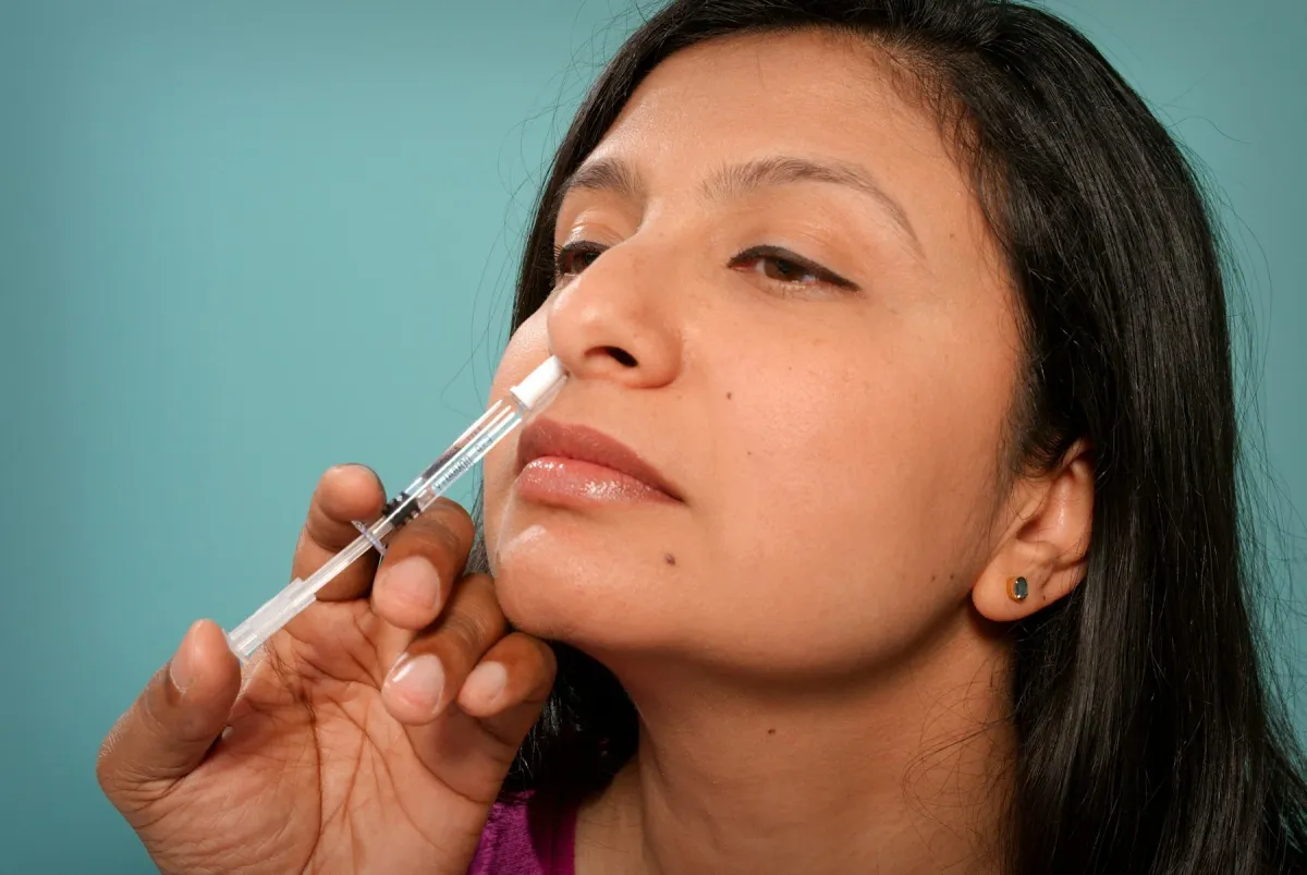 Mulher aplicando spray nasal