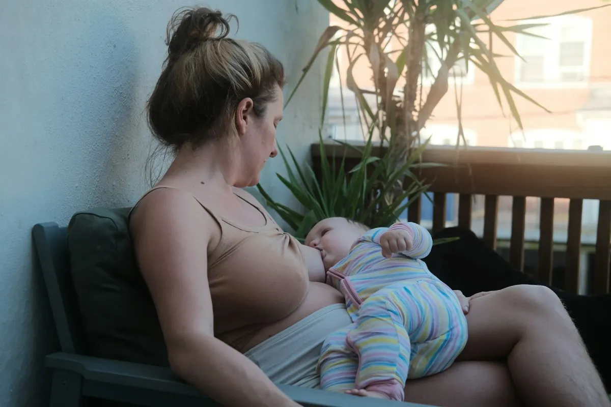 Mãe amamentando o bebê sentada em um banco