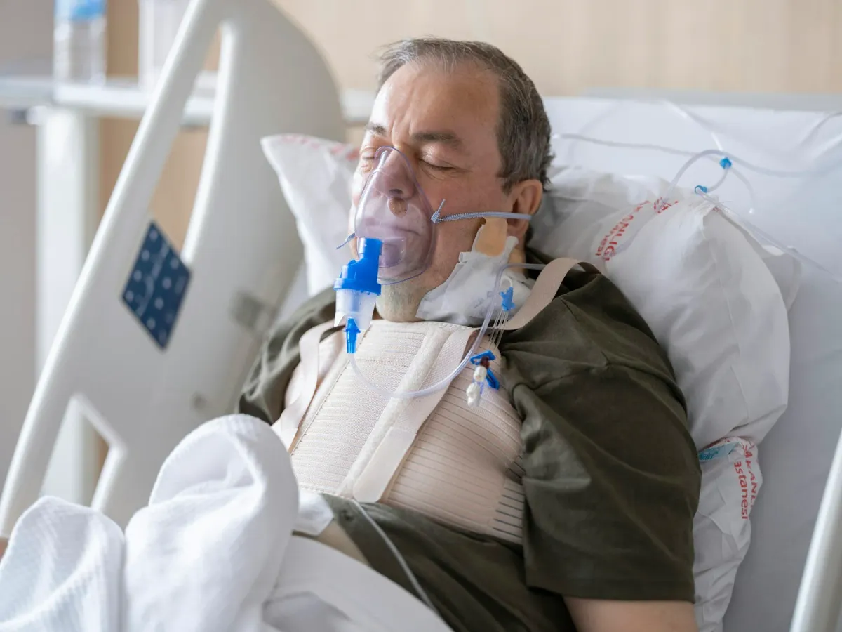 Paciente no leito hospitalar com máscara de oxigênio e nebulizador