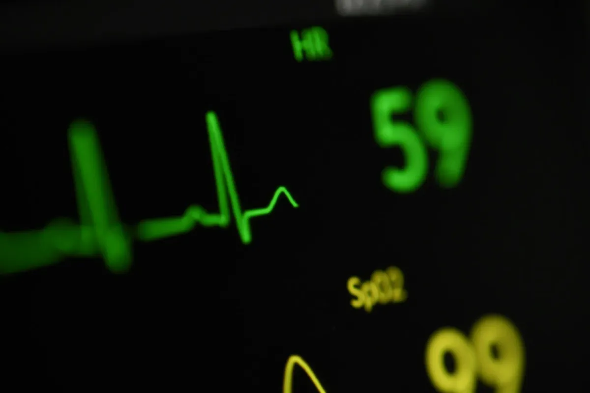 Monitor cardíaco com traçado de eletrocardiograma e saturação em verde