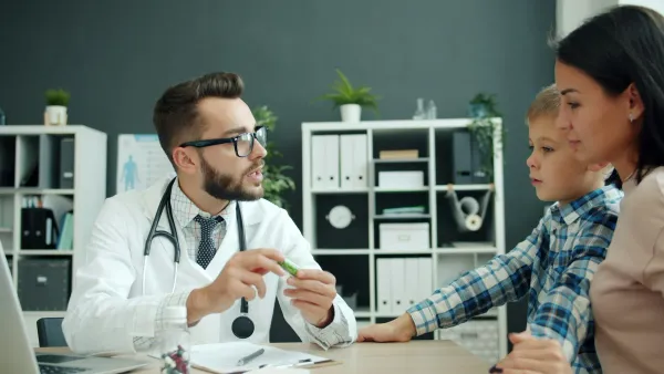 Médico explica a conduta à mãe e ao filho em consulta