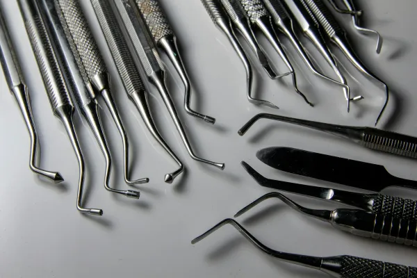 Instrumentais cirúrgicos de aço inoxidável dispostos sobre uma superfície clara