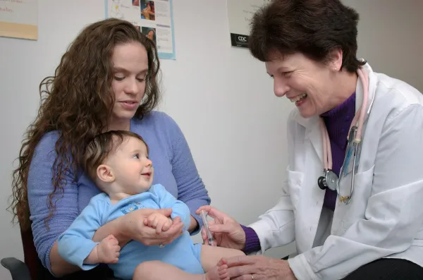 Médico examina uma criança pequena durante consulta pediátrica