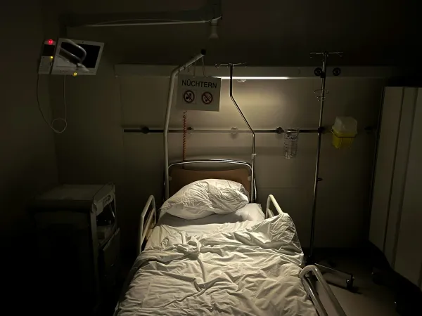 Quarto de hospital com cama e monitor em penumbra