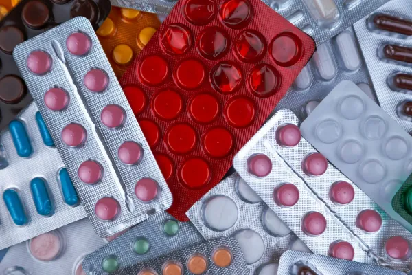Pilha de cartelas de comprimidos e cápsulas de várias cores