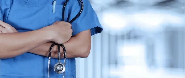 Profissional de saúde de uniforme azul com estetoscópio nos braços