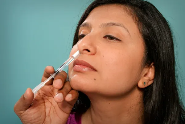 Mulher aplicando spray nasal