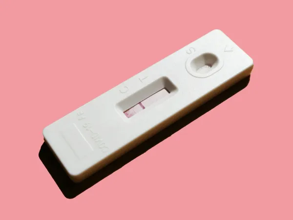 Teste de gravidez sobre fundo rosa