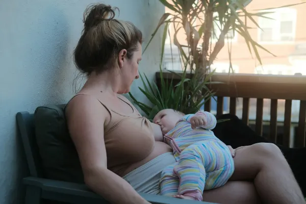 Mãe amamentando o bebê sentada em um banco