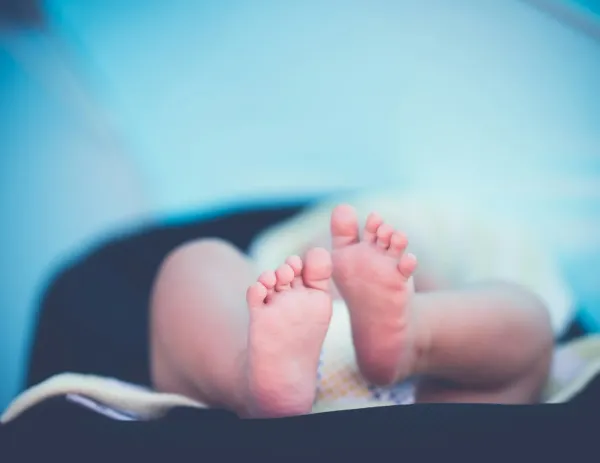 Pés de um bebê recém-nascido deitado em close