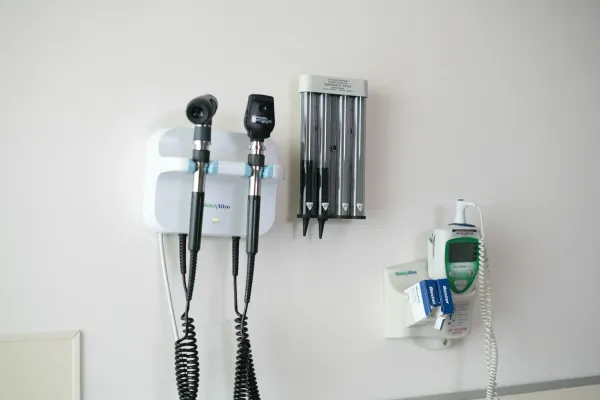 Otoscópio e oftalmoscópio fixados na parede de um consultório médico